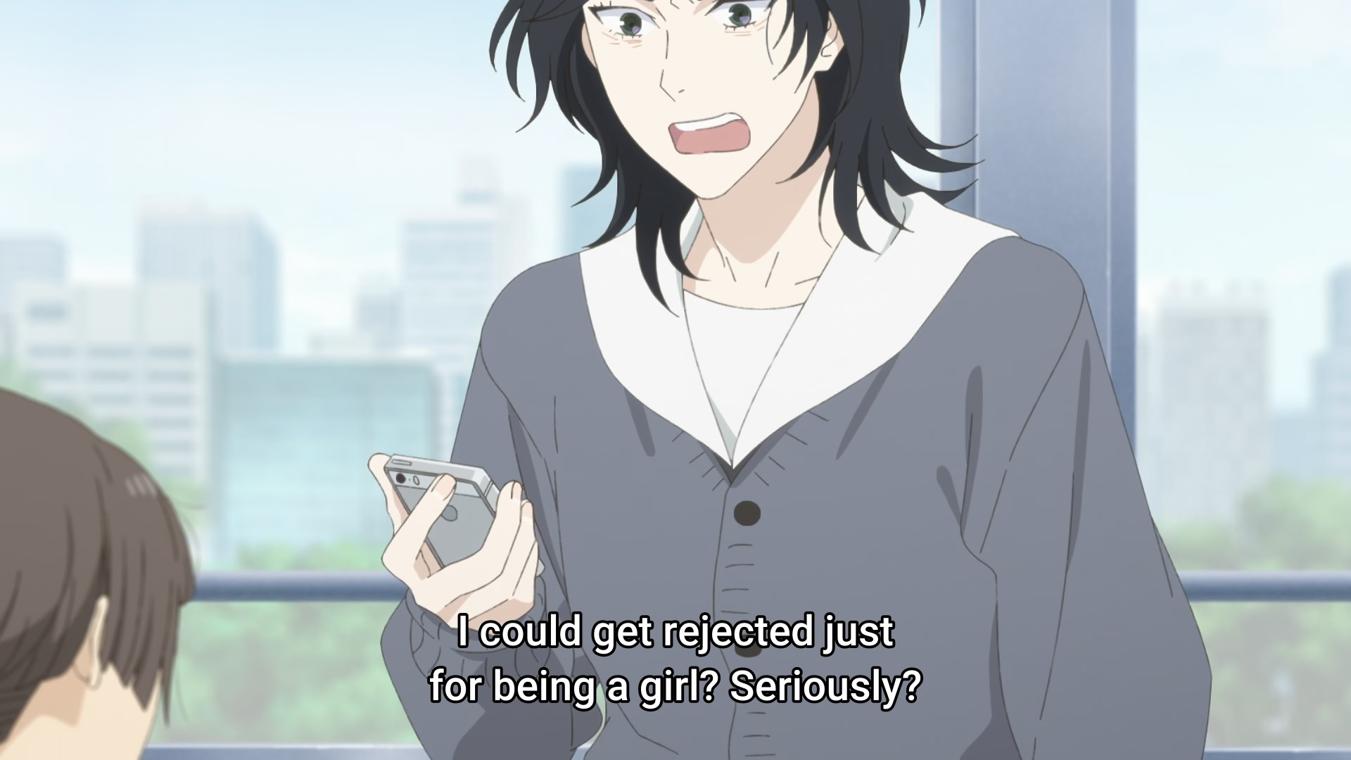 A high school girl looking at her phone in outrage, saying 'I could get rejected just for being a girl? Seriously?'
